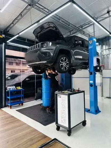 Jeep Renegade no elevador com técnico revisando a suspensão