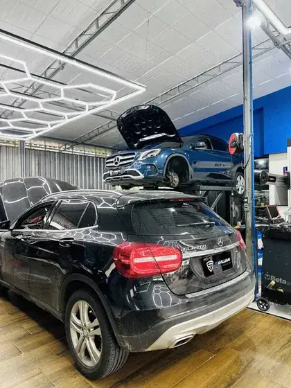 Mercedes GLA preta em primeiro plano e outra no elevador ao fundo
